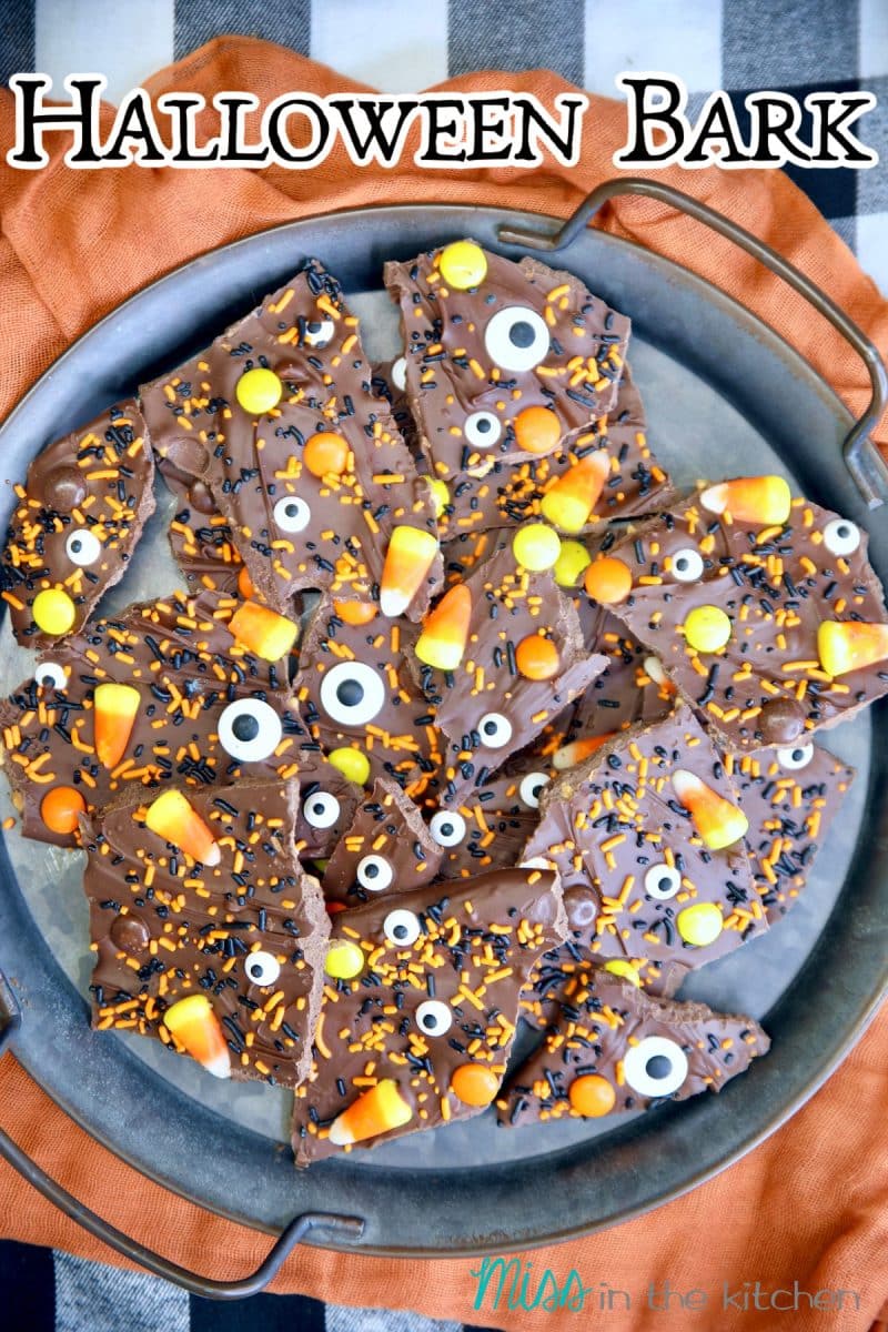 Halloween Bark on a tray with orange cloth. Text overlay.