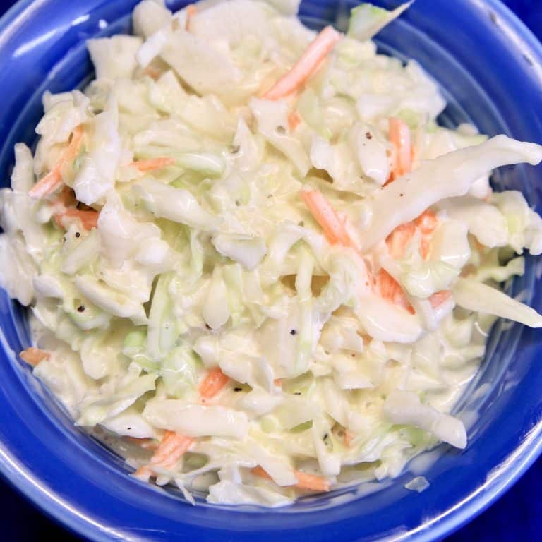 Blue bowl with homemade coleslaw with creamy dressing.
