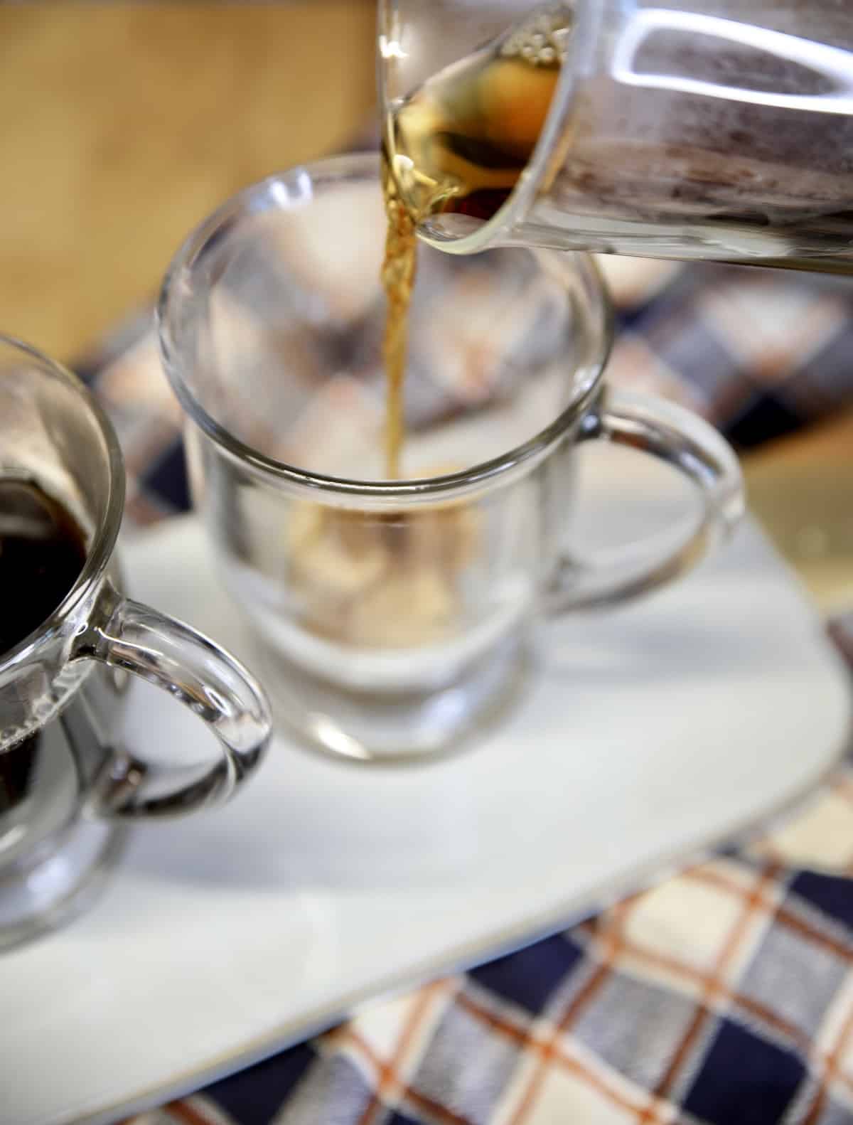 Pouring coffee into mugs with brown sugar.