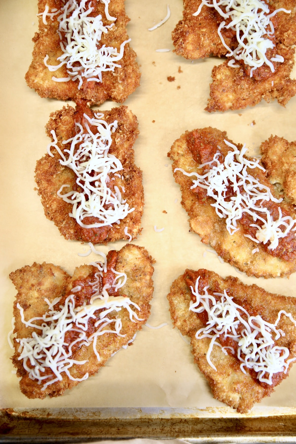 Parmesan chicken with sauce and shredded mozzarella.