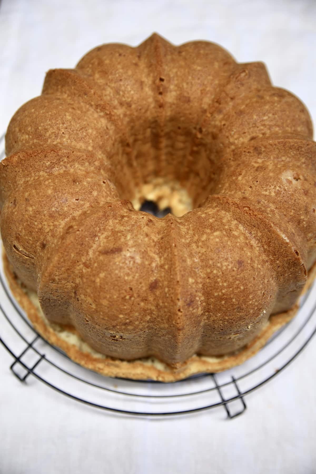 Wire rack with baked bundt cake.