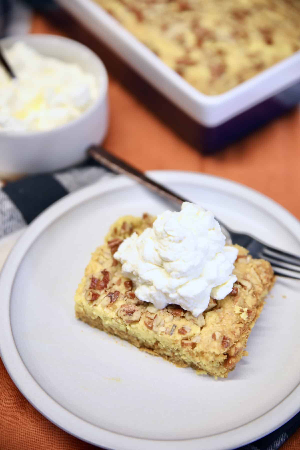 Pumpkin Pie Cake on a saucer with whipped cream. 