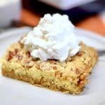 Pumpkin pie cake with whipped cream on a plate.