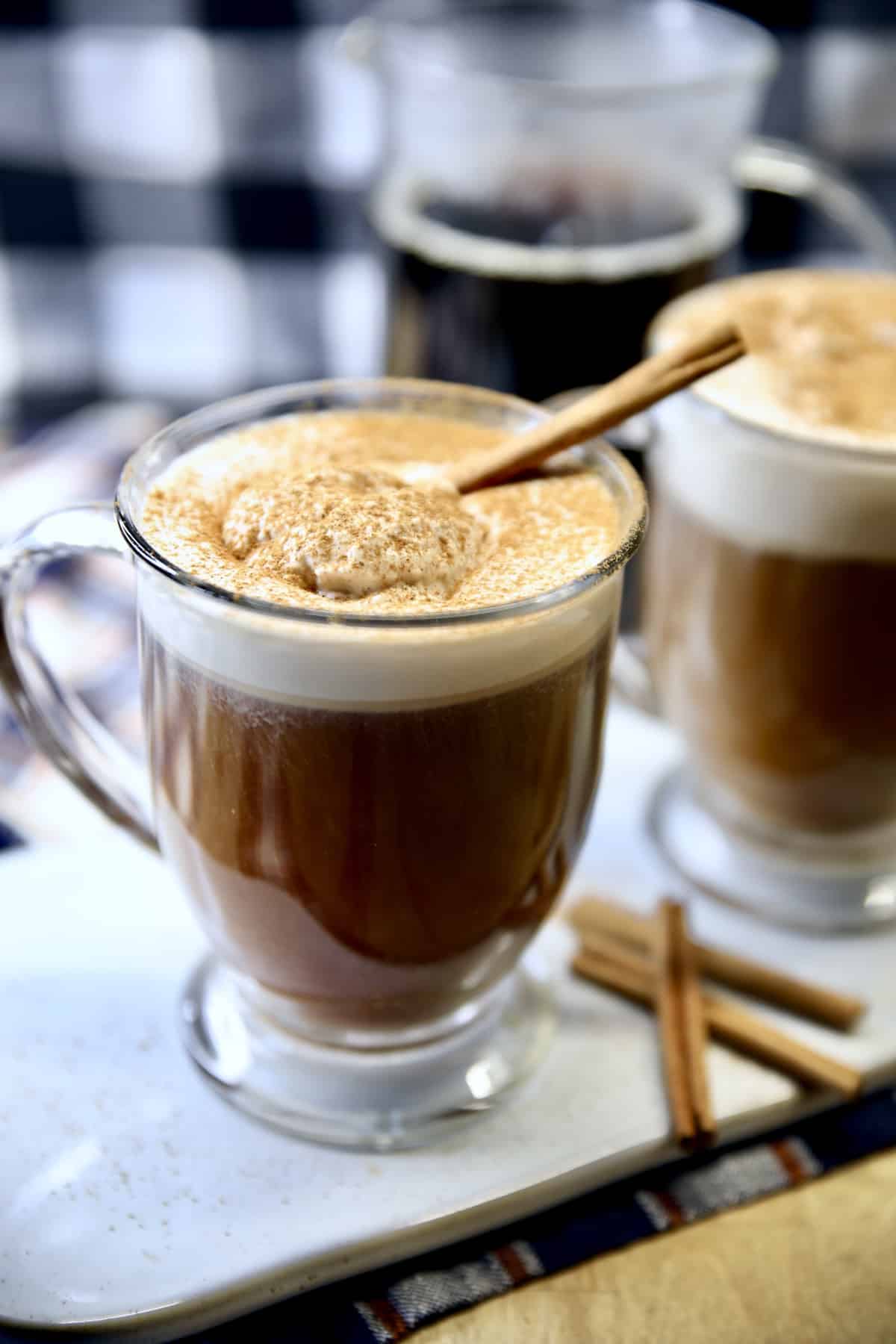 Pumpkin Spice Irish Coffee in mugs with cinnamon stick.