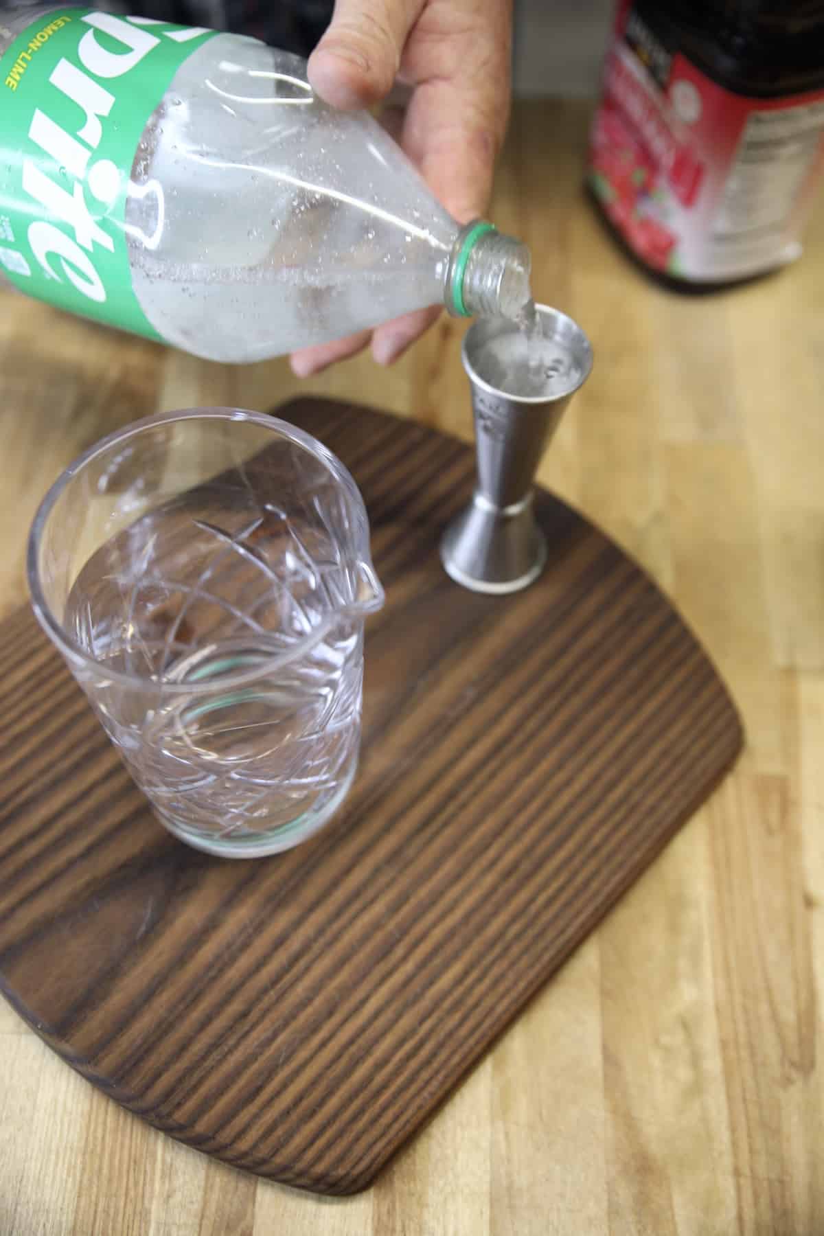 Making cranberry cocktail with sprite.