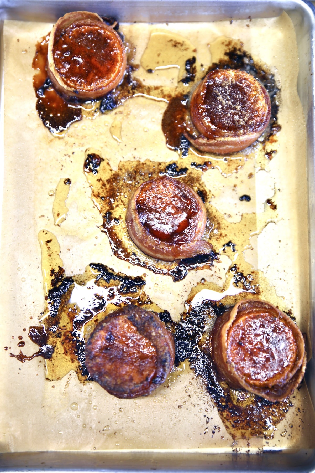 Baking sheet with bacon wrapped sweet potato stacks.