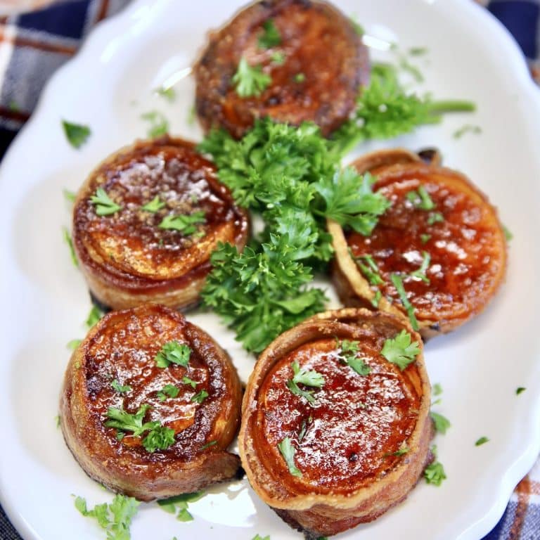 Bacon wrapped sweet potatoes on a platter.