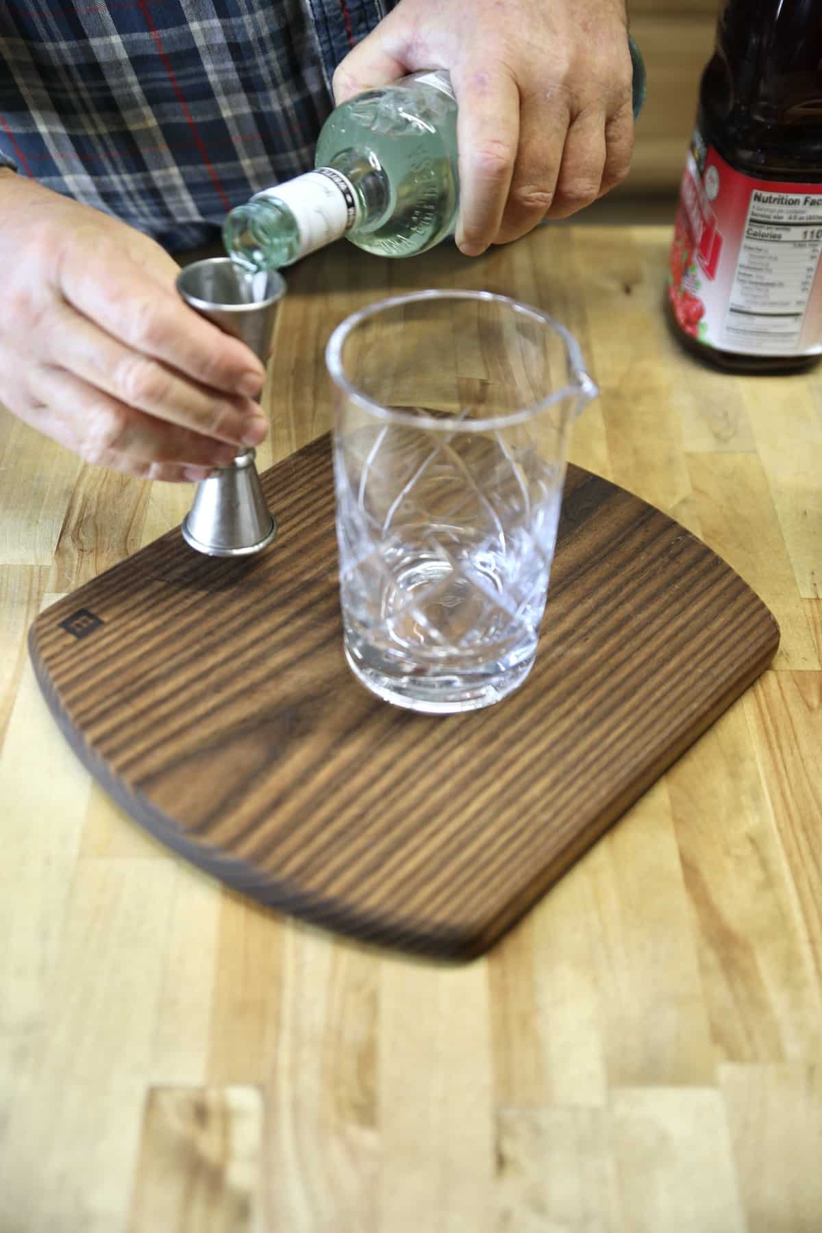 Pouring rum into a jigger.