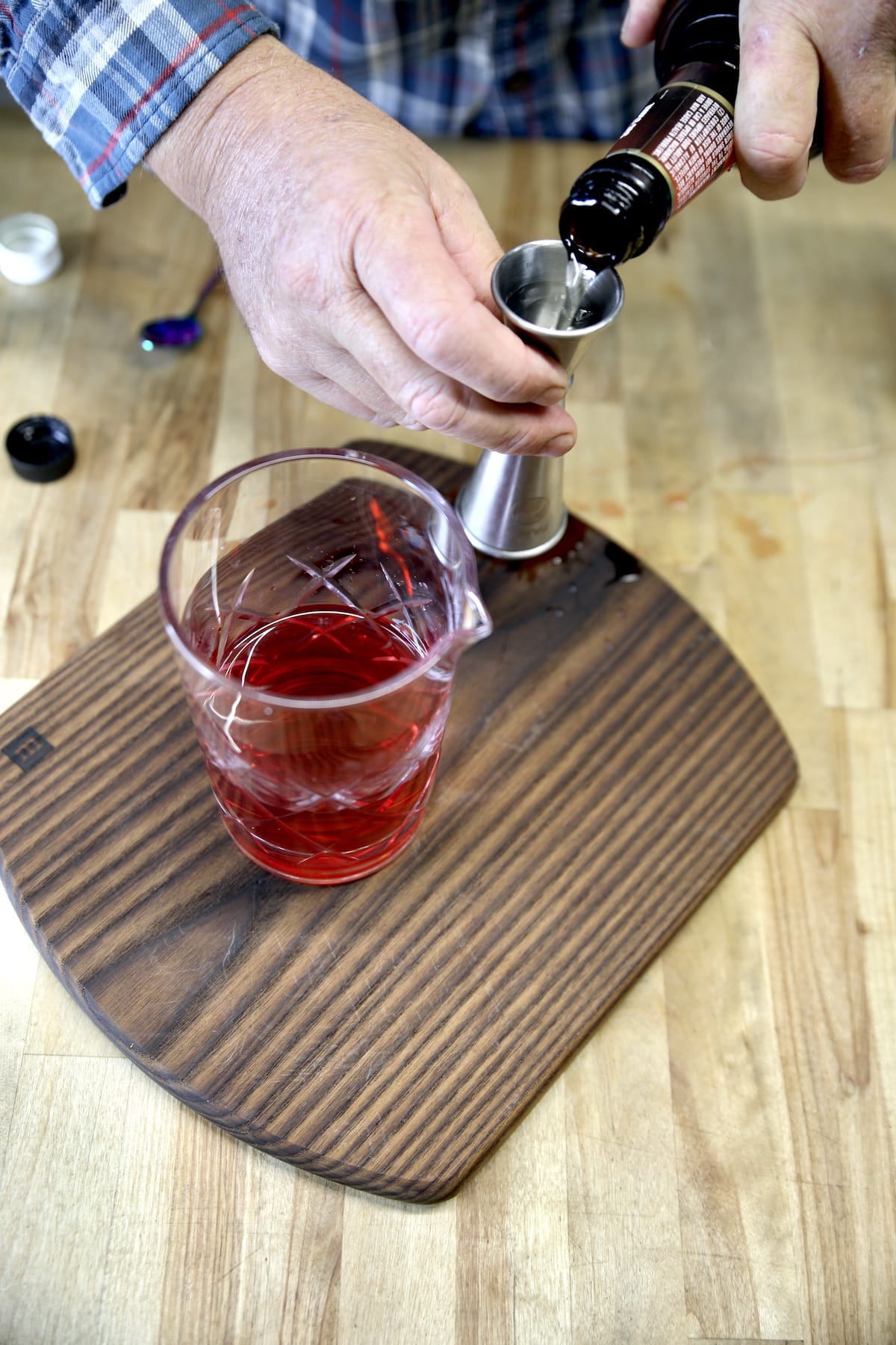 Pouring triple sec into a jigger.