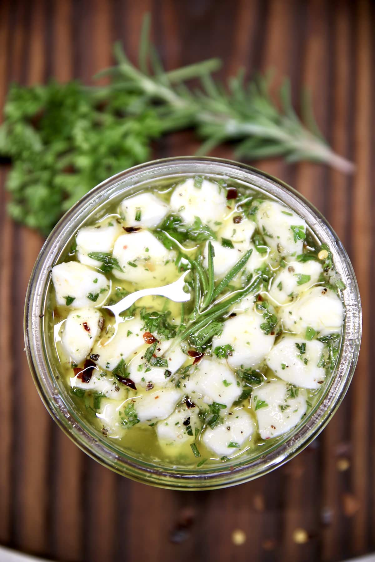 Overhead of jar of marinated mozzarella balls.