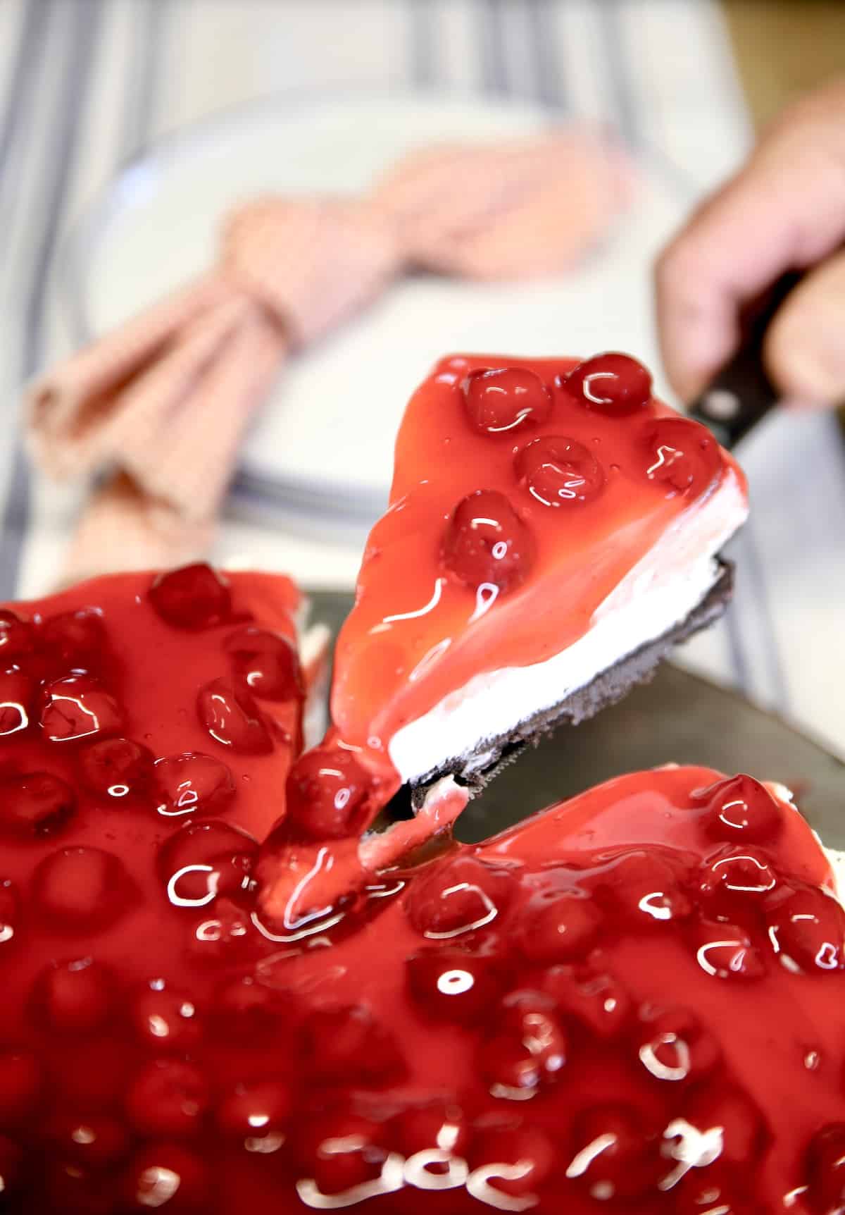 Serving Cherry cheesecake slice.