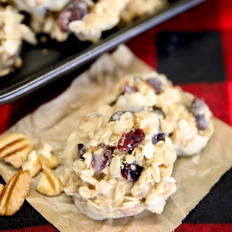 White chocolate cranberry cookies on a piece of parchment.