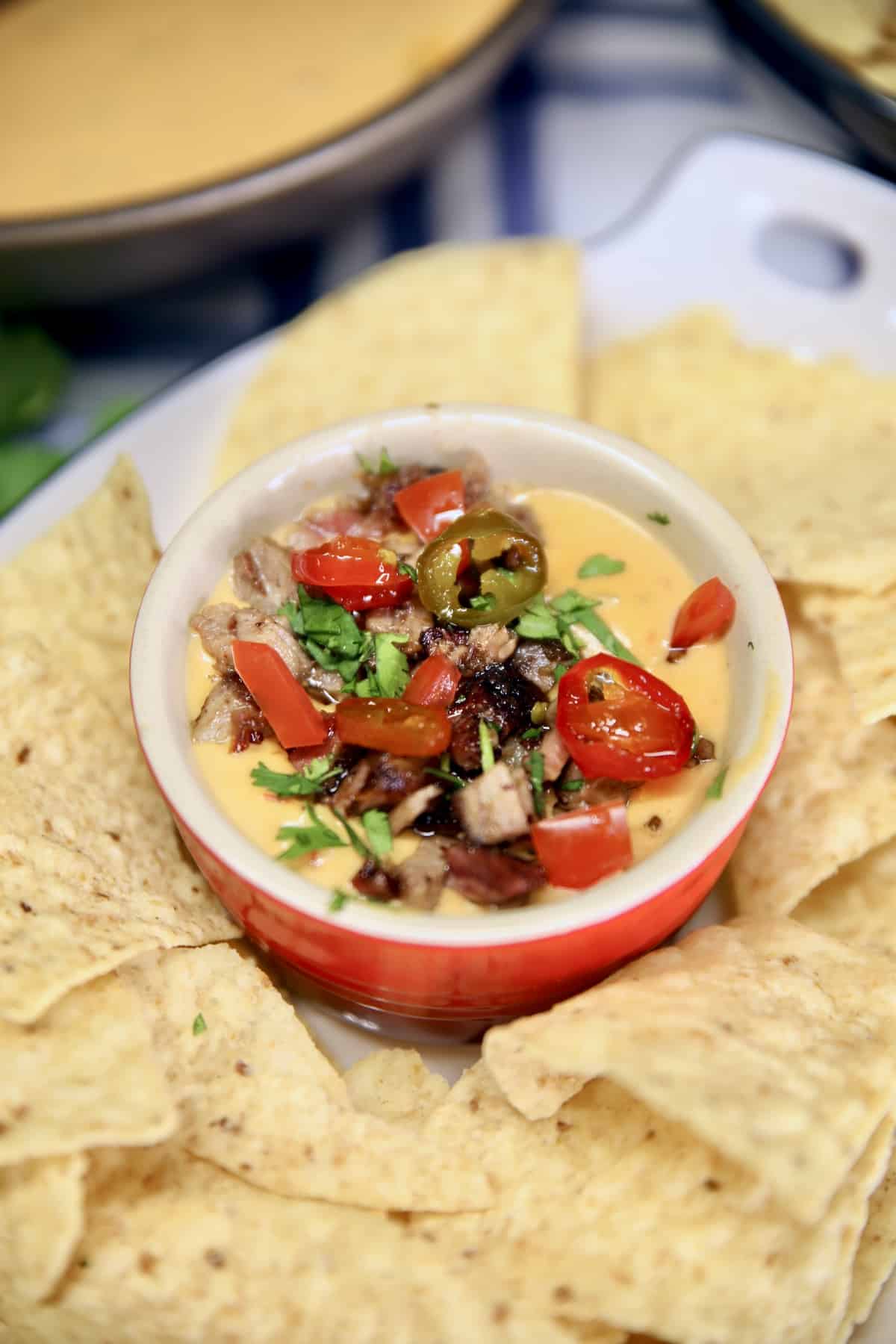 Closeup of bowl of brisket queso with tortilla chips.