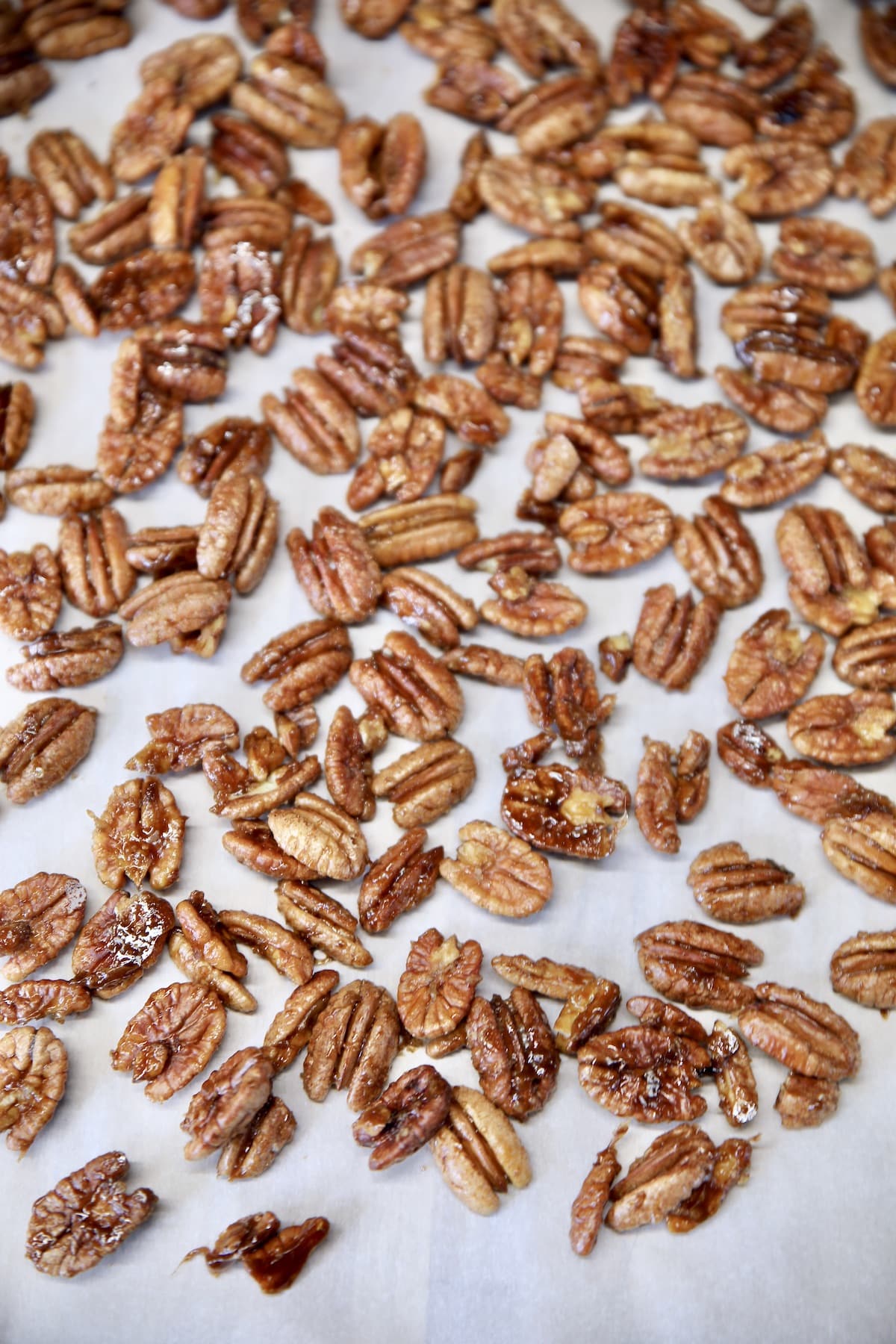 Baked candied pecans on a baking sheet.