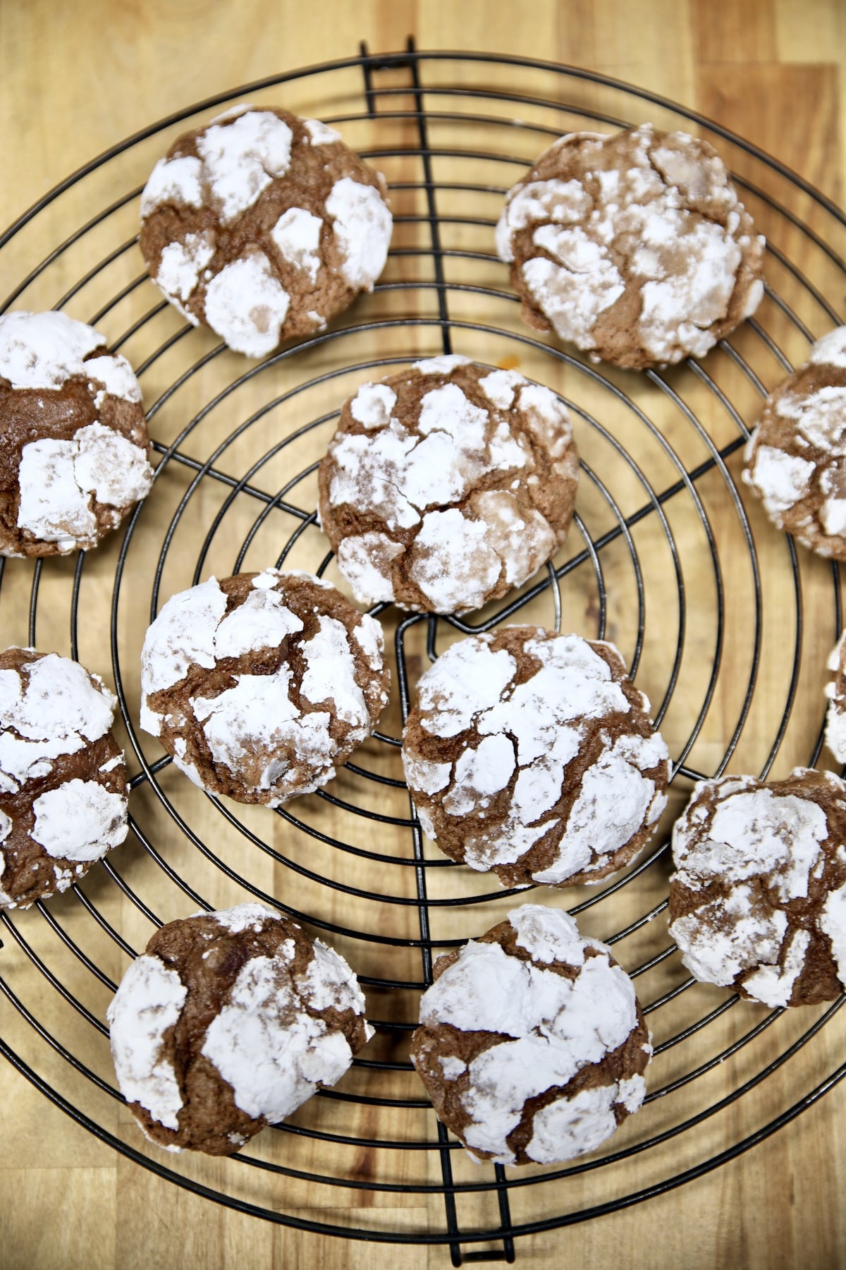 Chocolate crinkle cookies on a wire rack.