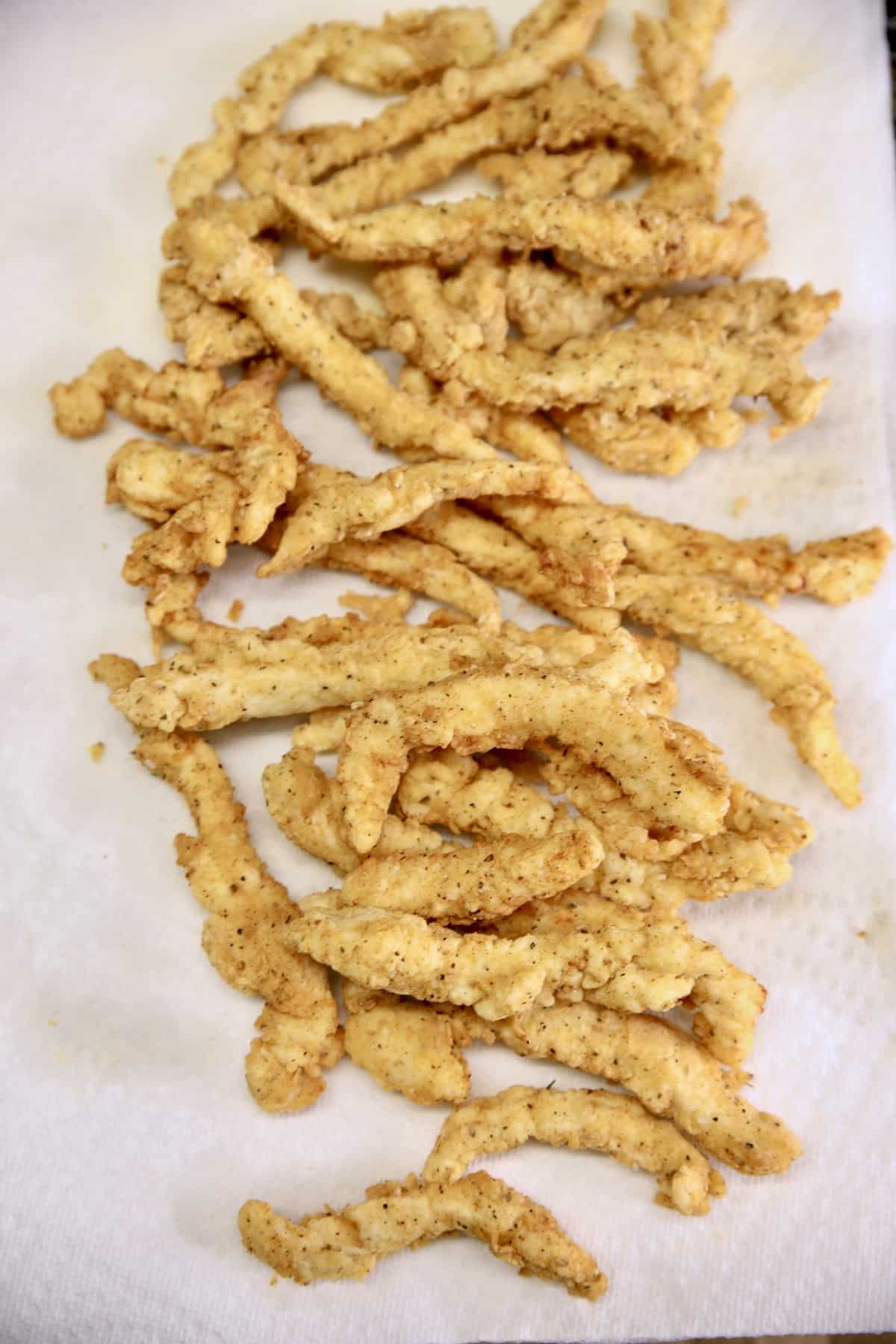 Chicken fries draining on a paper towel. 
