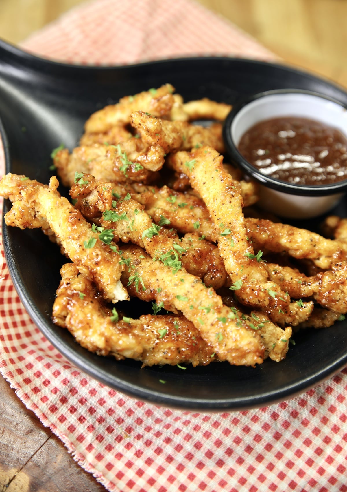 Black dish with honey bbq chicken fries, dippings sauce.
