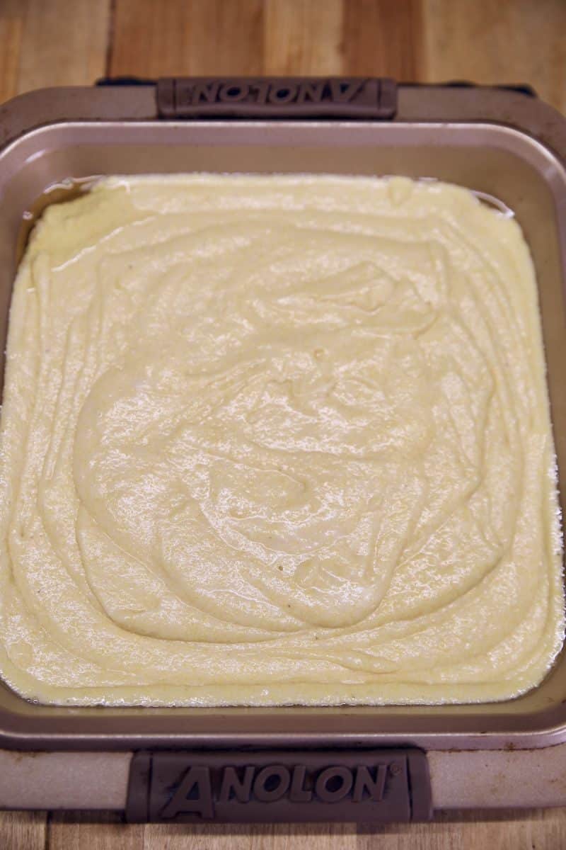 Cornbread batter in a square baking pan.