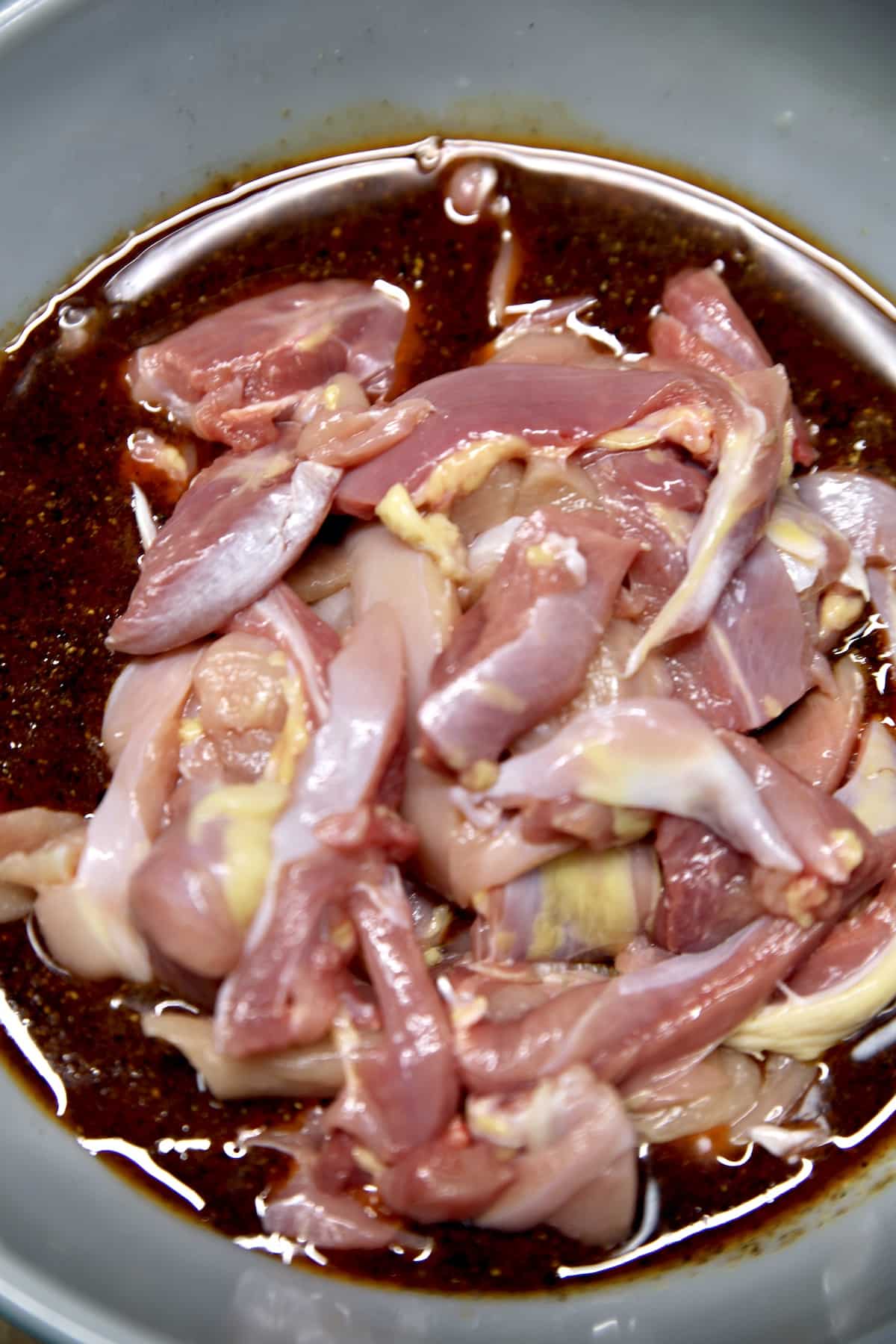 Chicken in bowl of fajita marinade.