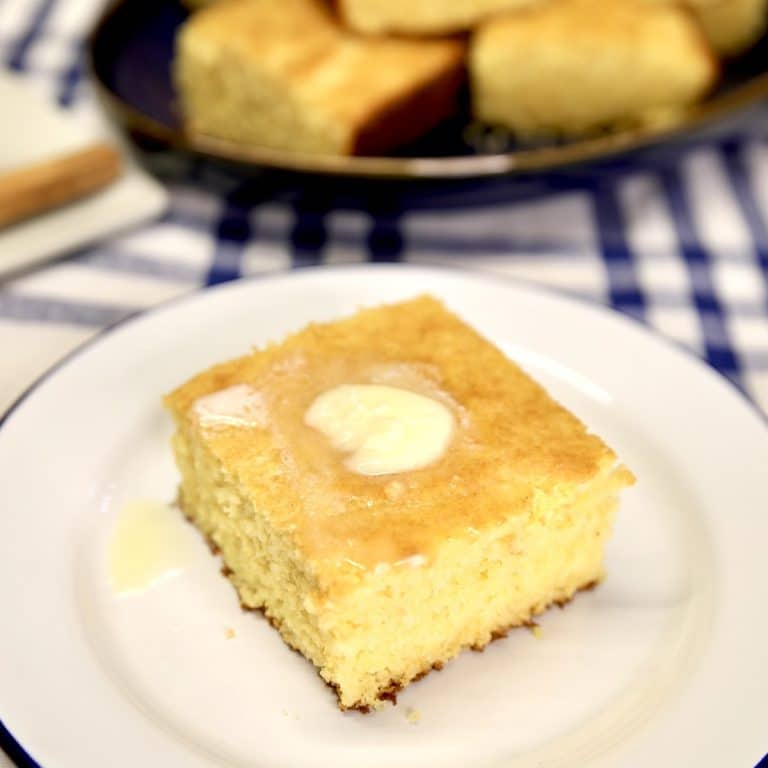 Slice of cornbread with pat of butter on top.