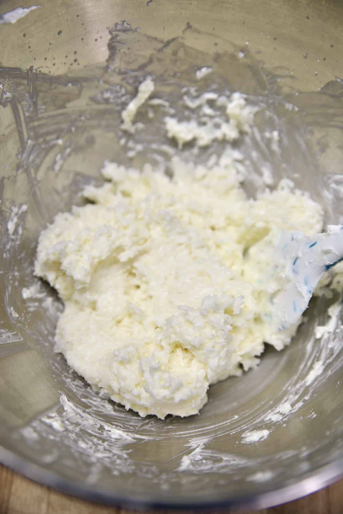 Coconut and cream cheese mixture in a mixer bowl.