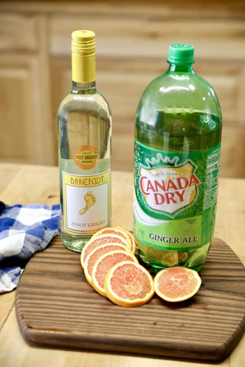 Bottle of pinot grigio, Ginger ale, slices of orange.