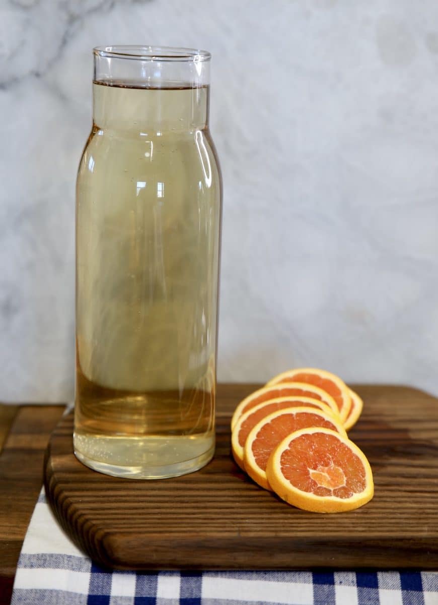 Pitcher of wine spritzer with orange slices.