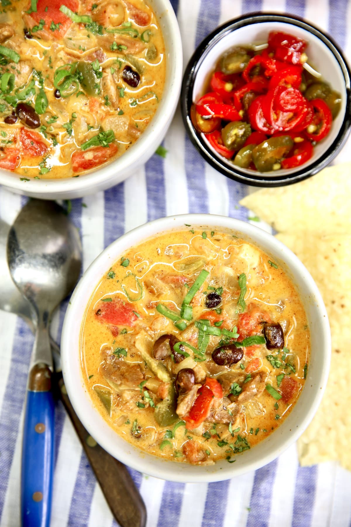 2 bowls of chicken enchilada soup with black beans. Small bowl of jalapenos.