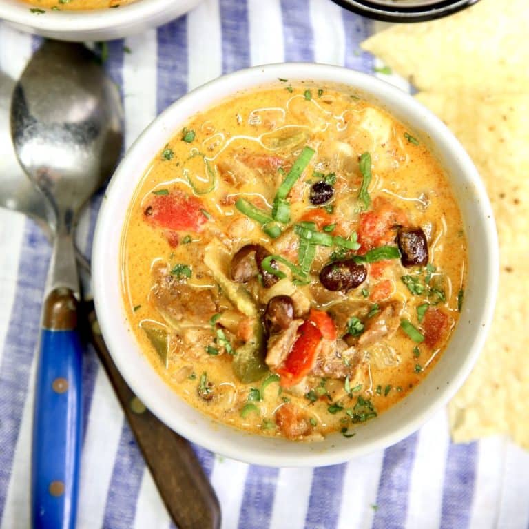 Chicken enchilada soup in a bowl. Spoon to the side.