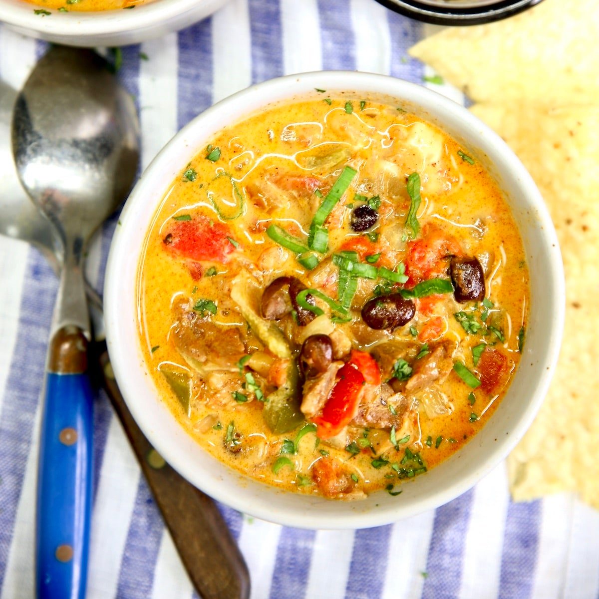 Chicken enchilada soup in a bowl. Spoon to the side.