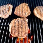 4 pork chops on a grill.