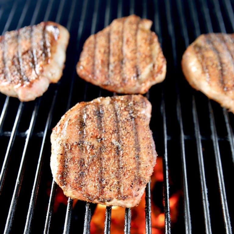 4 pork chops on a grill.