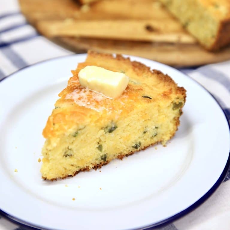 Slice of jalapeño cheddar cornbread with melting butter on top.