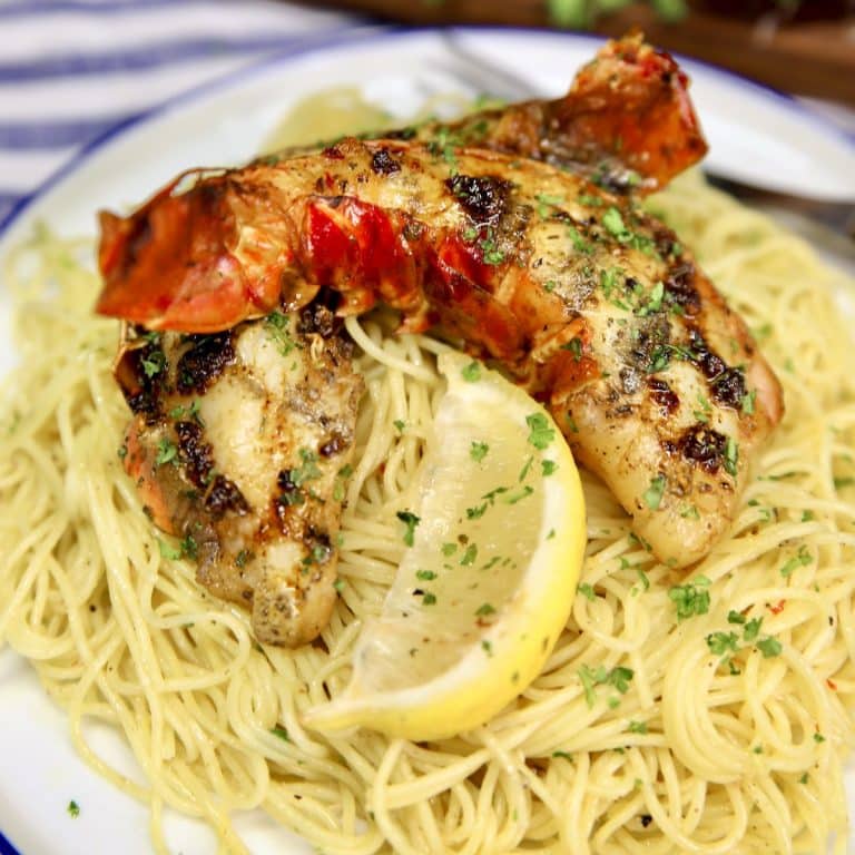 Lobster tails cut in half over lemon spaghetti pasta.