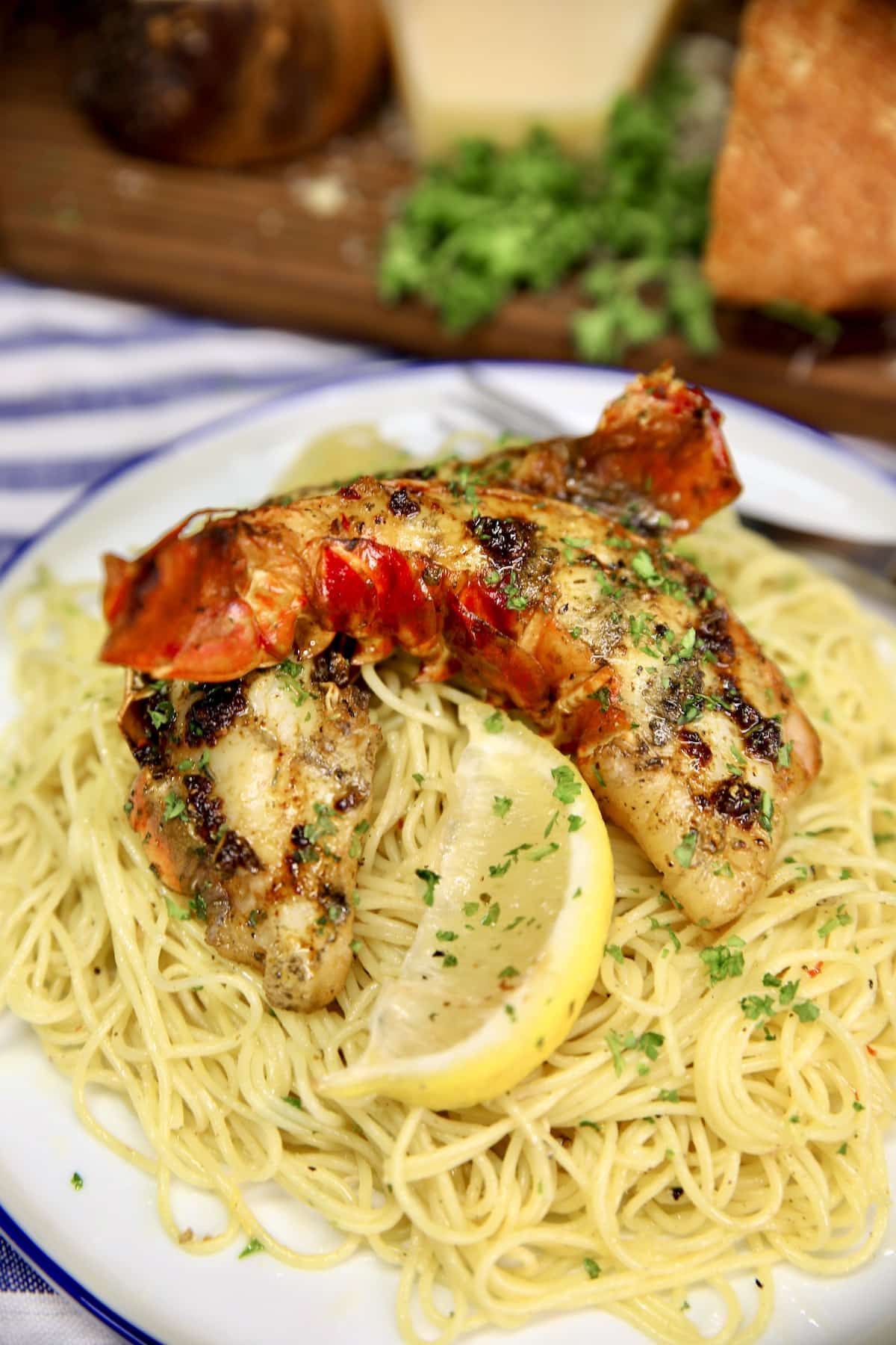 Plate of angel hair pasta with lobster tail, cut in half.