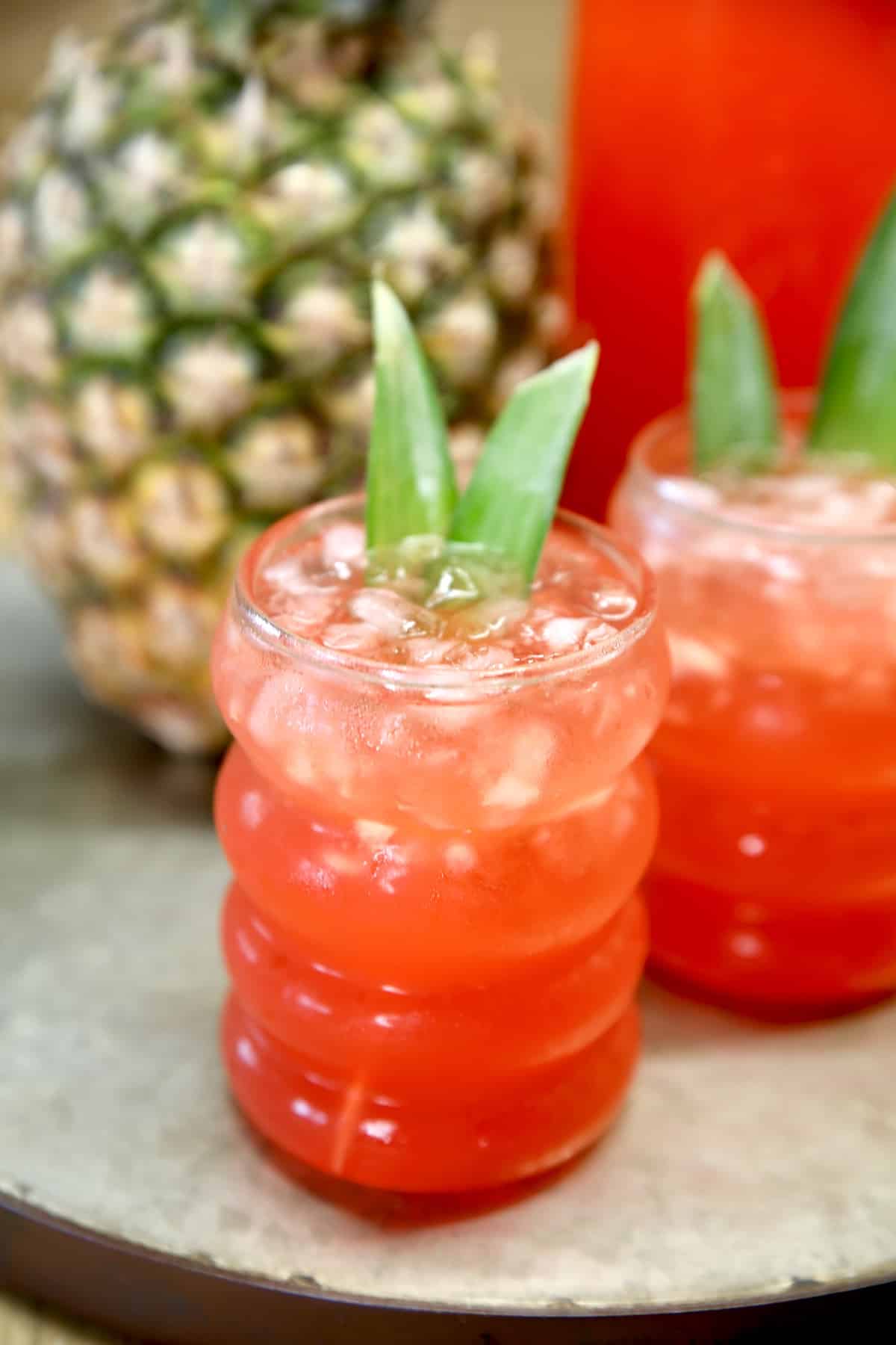 Rum Punch is a super easy pitcher cocktail to make for any party, get together or celebration. It's made with just 4 ingredients for the best party punch! 2 glasses of red rum punch, fresh pineapple.