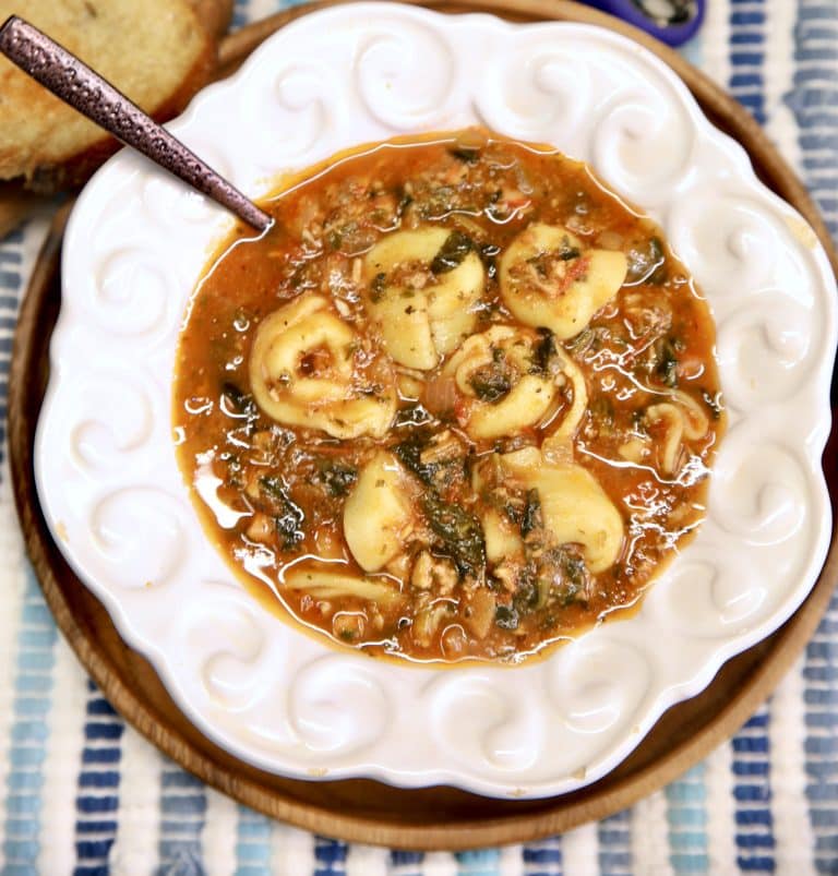 Bowl of tomato tortellini soup with spoon.