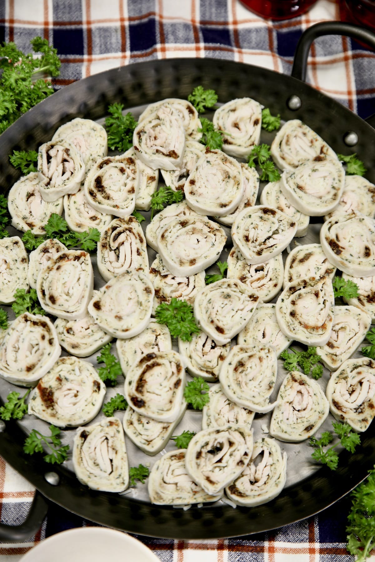 Turkey pinwheels on a black tray.
