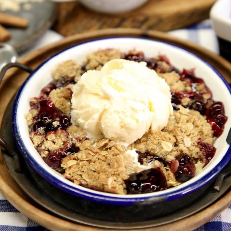 Bowl of Blueberry Crisp with scoop of vanilla ice cream.