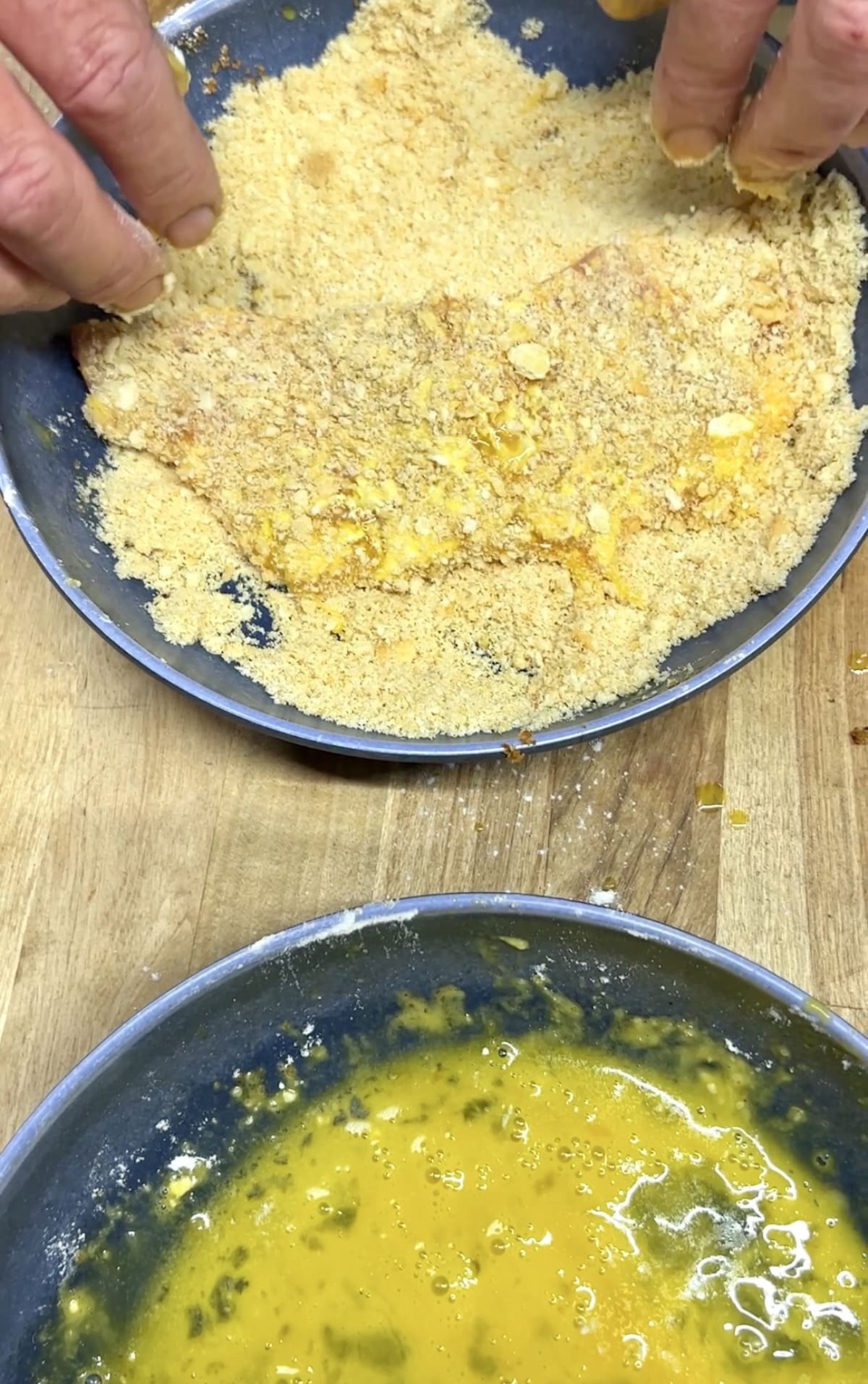 Coating pork cutlets in breadcrumbs.