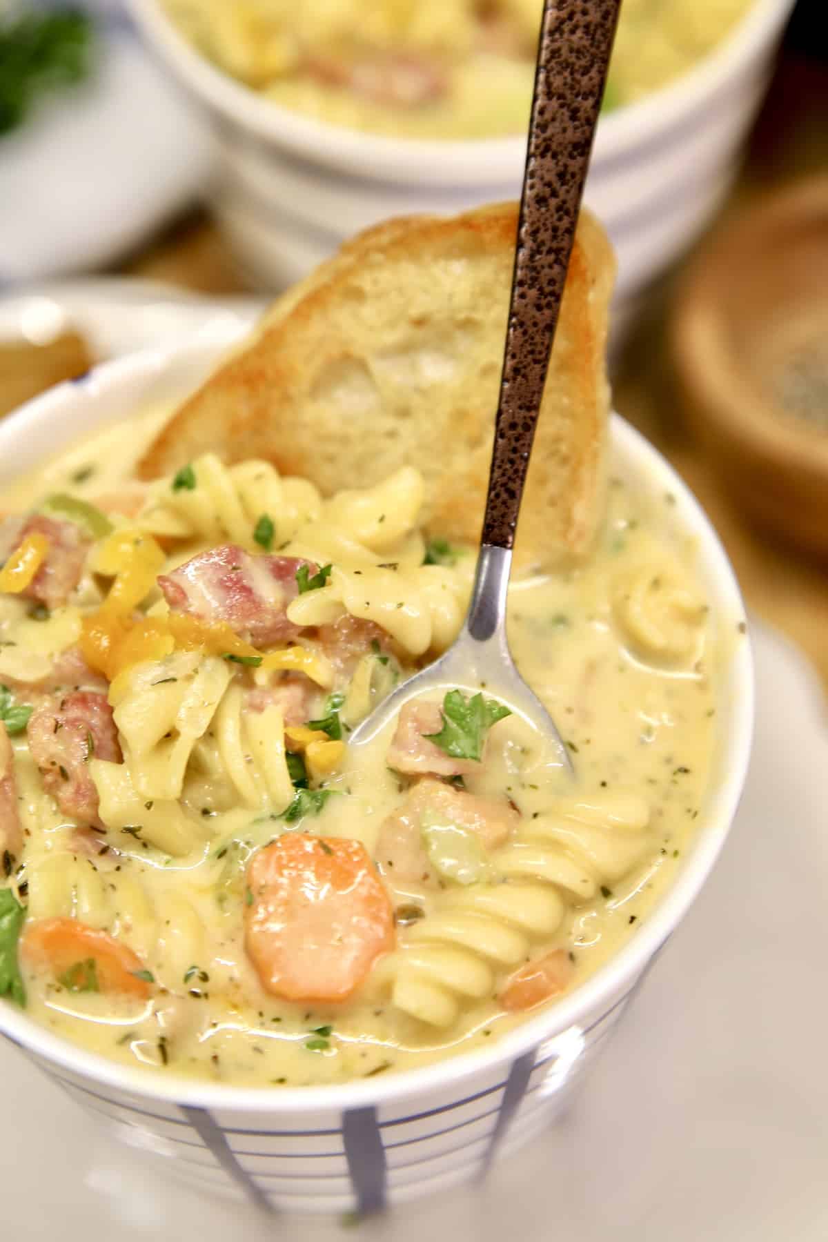 Mug of ham soup with spoon.