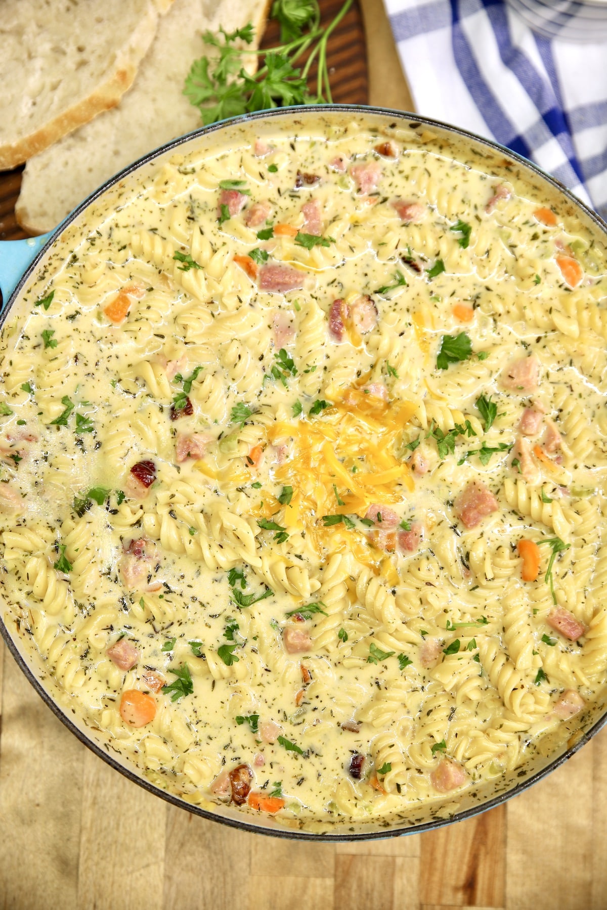 Pan of ham and cheese soup with vegetables and pasta.