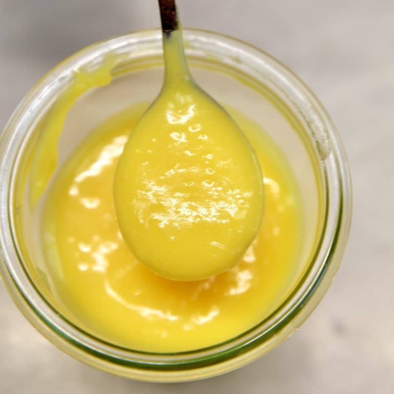 Spoonful of lemon curd in the top of a jar.