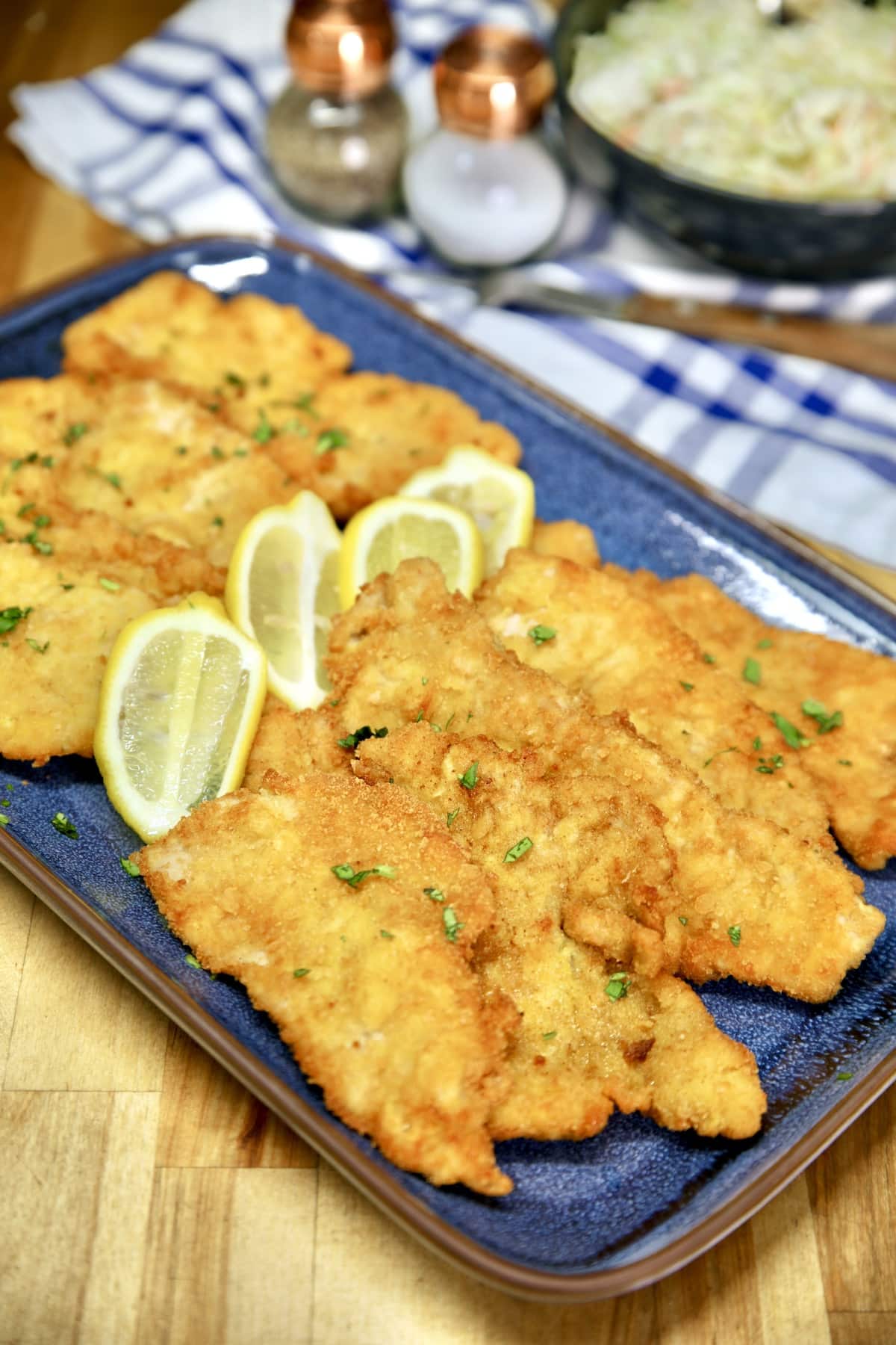 Platter of pork schnitzel with sliced lemons.