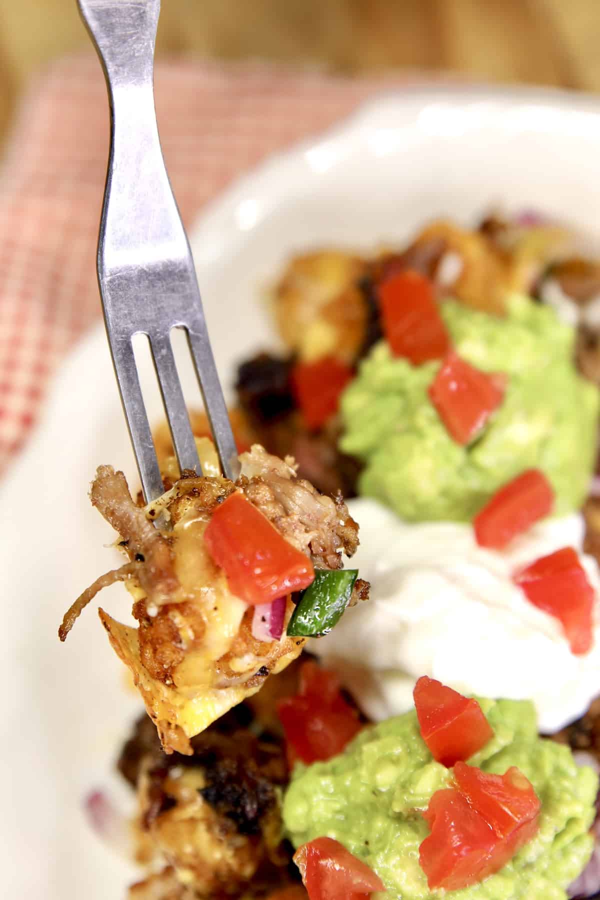 Bit of tater tot nachos on a fork.
