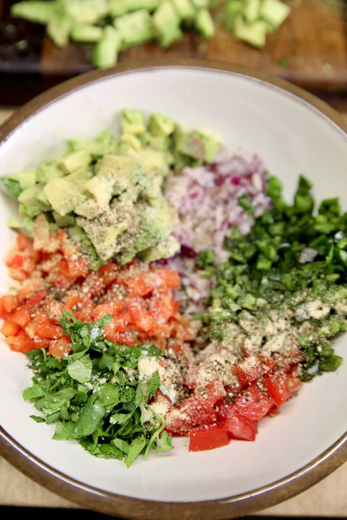 Chopped avocados, onions, peppers, tomatoes in a bowl