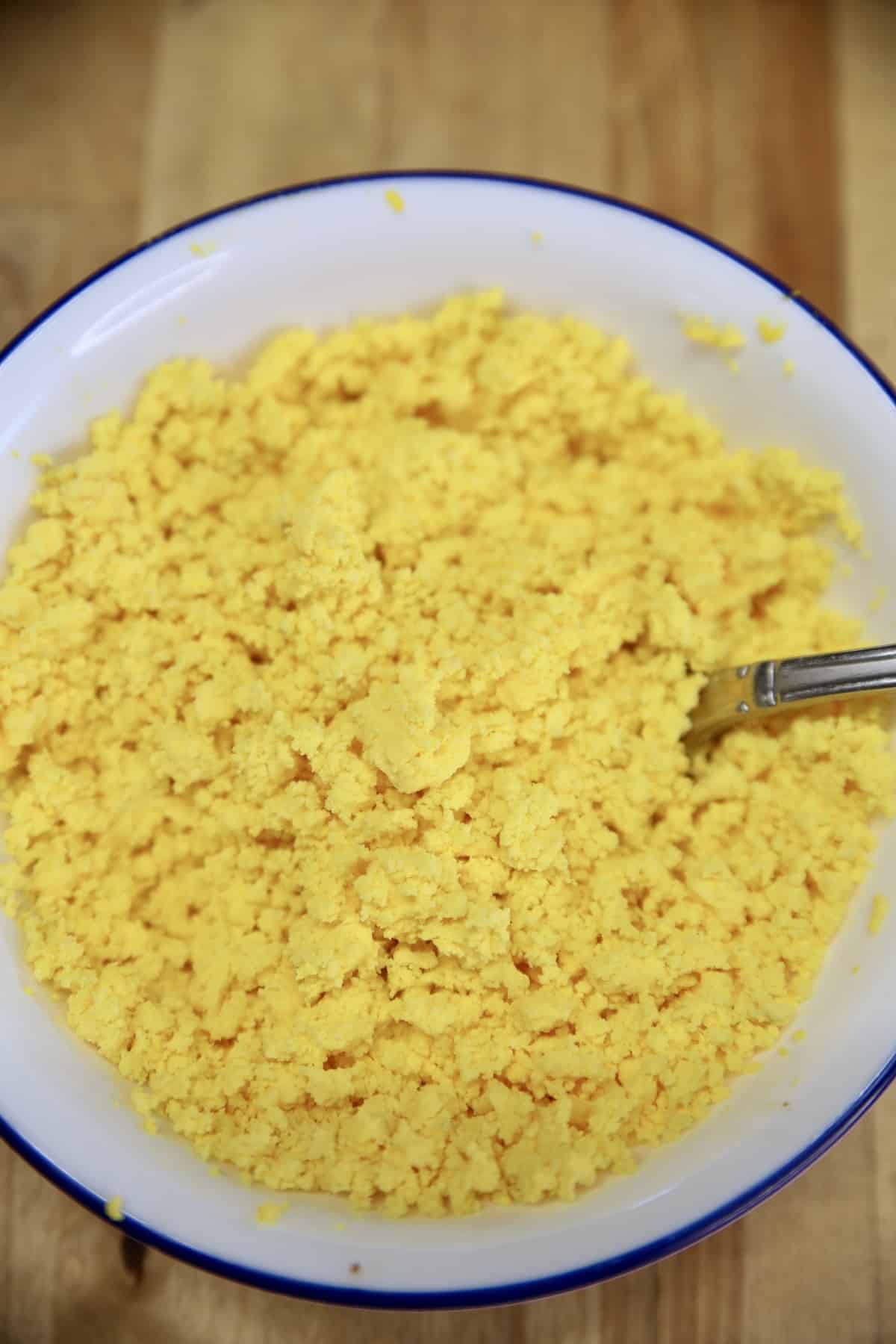 Hard boiled egg yolks smashed in a bowl with a fork.