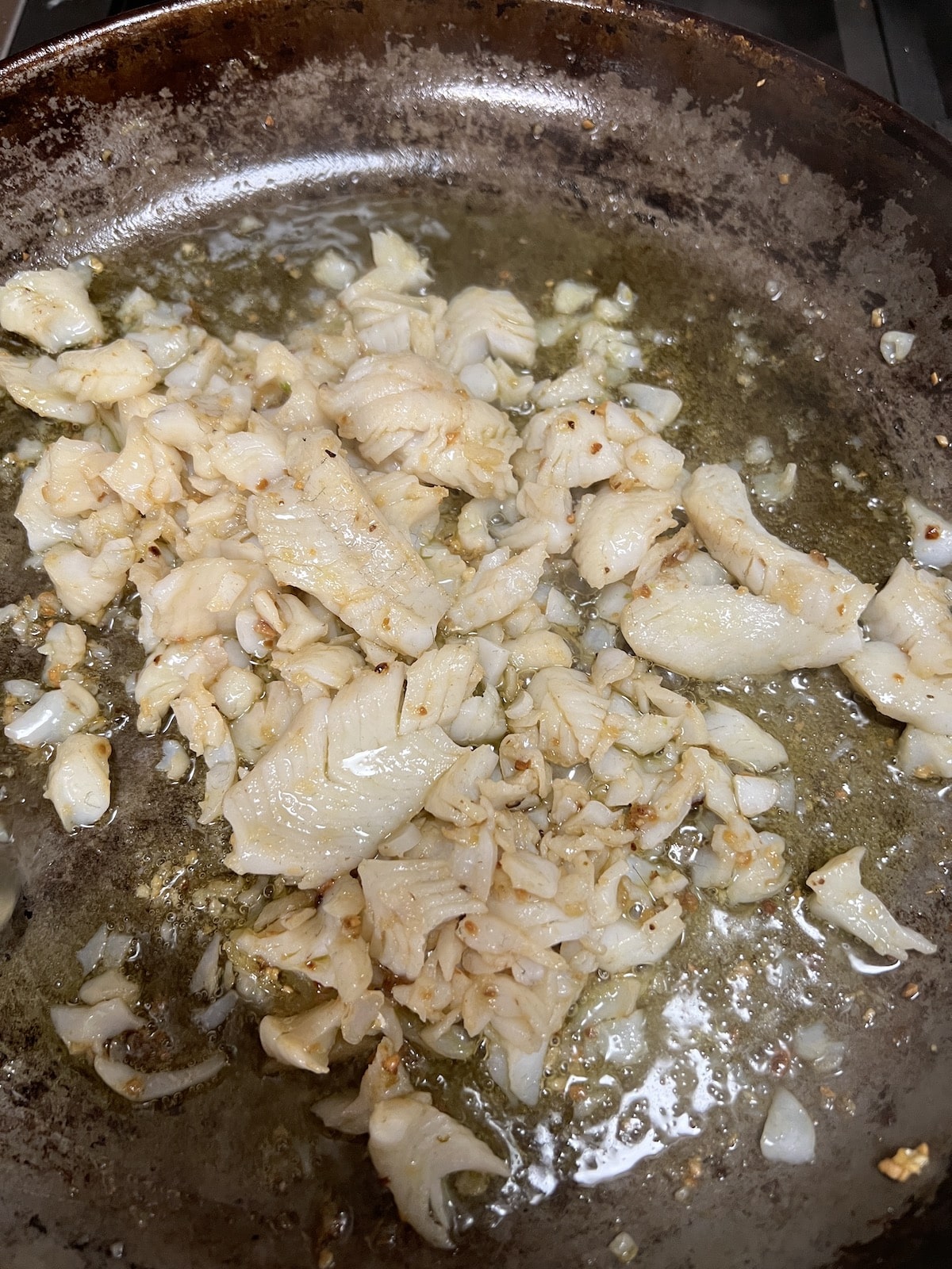 Fish sauteed in a skillet.