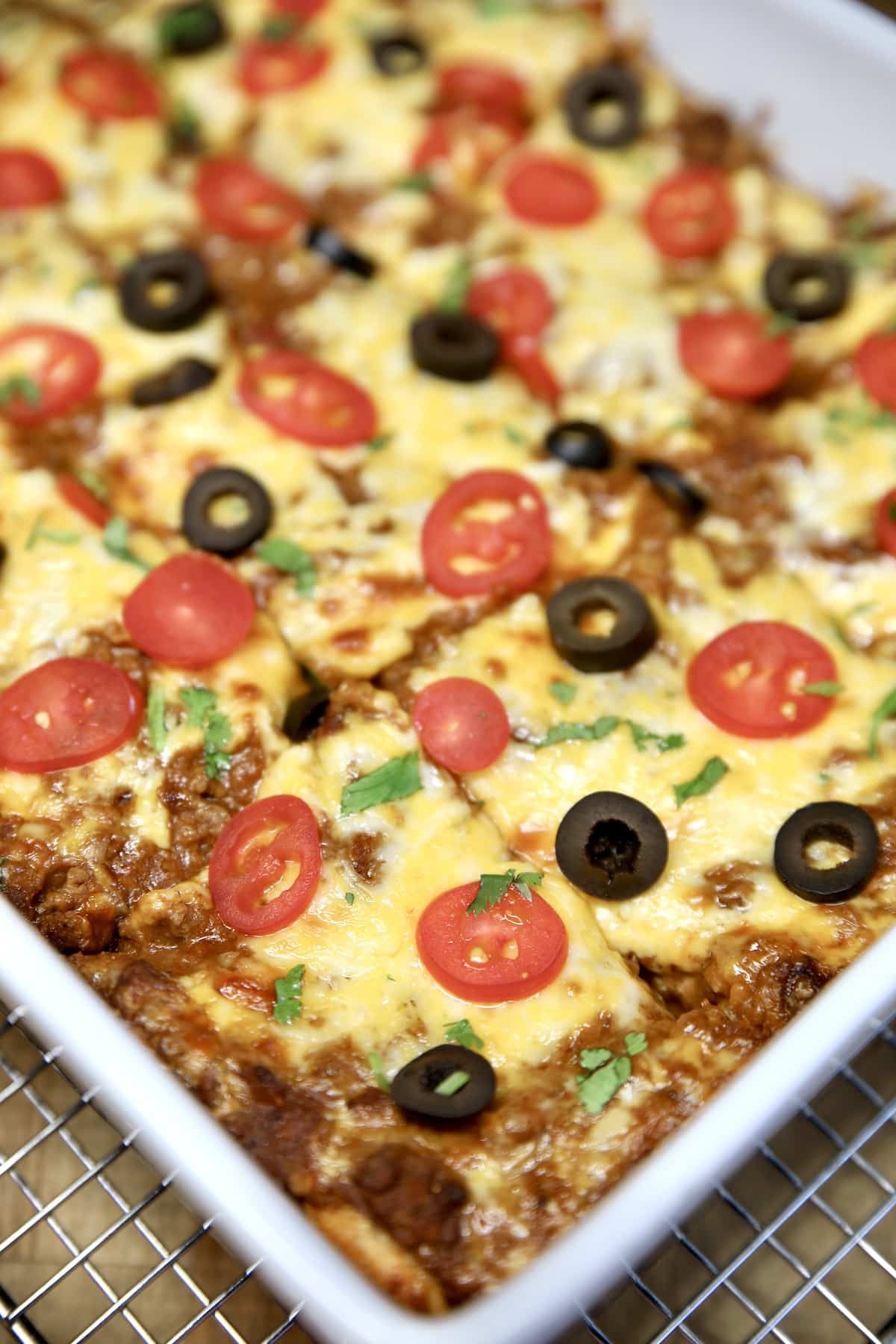 Casserole with ground beef and bean burrito bake, cut into squares.