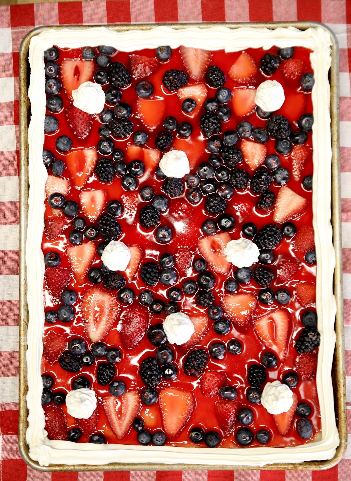 Sheet pan fresh berry pie with cool whip in a sheet pan.